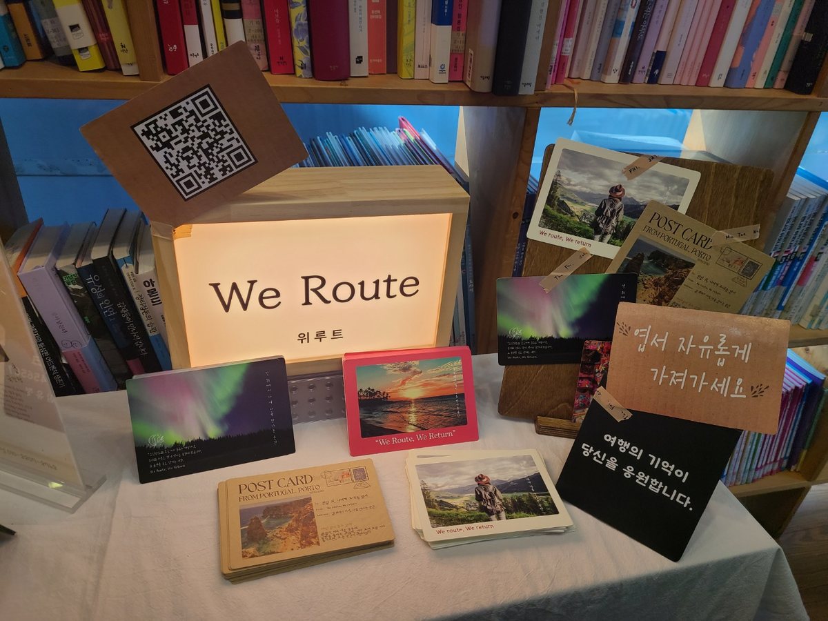 We Route 라이트박스 옆에 놓인 여행 엽서들